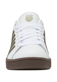 Tenisky K-Swiss s bielym syntetickým zvrškom, zelenými bočnými pruhmi a hnedou gumovou podrážkou. Šnurovací dizajn s logom na jazyku.