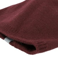 Burgundy knitted scarf made from soft material, featuring a ribbed edge and a subtle branded tag along the hem.
