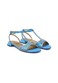 Sandali piatti blu con design a T, caratterizzati da dettagli in strass e una finitura liscia. Il materiale comprende una tomaia sintetica e una soletta imbottita.