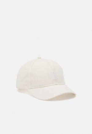 Gorra de béisbol blanca con visera curva y discreto logo bordado de CK en el panel frontal, mostrada sobre un fondo claro y liso.
