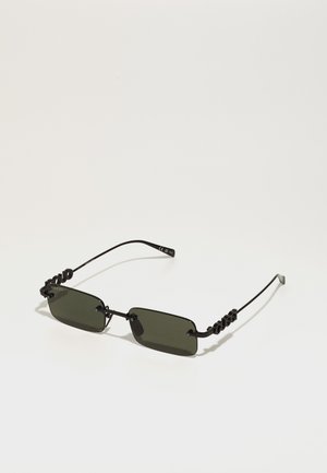 Óculos de sol de metal preto com lentes retangulares verde-escuro, apresentando um design de armação torcido e único. Design minimalista com uma marcação discreta.