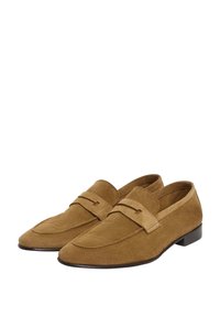 Bruna mockasiner i mocka med en slip-on design, platt klack och ett dekorativt band över ovandelen med subtila sömmar.