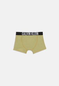 Olijfgroene boxershorts met zwarte tailleband, waarop in witte letters "CALVIN KLEIN" staat, plat weergegeven op een witte achtergrond.