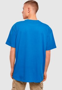 Blå bomulds-T-shirt med en afslappet pasform, kortærmede og rund halsudskæring. Stoffet ser glat ud uden synlige mønstre eller accenter.