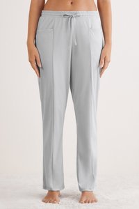 Lichtgrijze, rekbare loungebroek met een elastische tailleband, verstelbaar trekkoord en twee voorzakken. Gladde textuur en een ontspannen pasvorm.