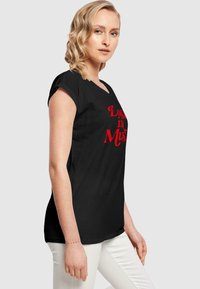 Svart t-skjorte med v-hals og korte ermer, med rød tekst som sier "Lost in Music". Laget av mykt stoff, med en slim fit-design.
