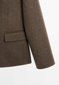 Brown wool blazer featuring a structured design, single breast, and a discreet pocket detail on the left side of the front.