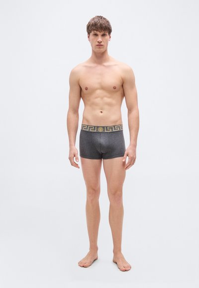 Γκρι μποξέρ σλιπ με υφή και ζώνη μέσης σε μαύρο και χρυσό με σχέδιο. Ο σχεδιασμός είναι απλός και εφαρμοστός.