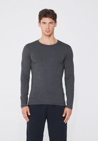 Dunkelgraues Langarmshirt mit rundem Halsausschnitt und tailliertem Design. Weicher Stoff ohne sichtbare Muster oder Akzente.
