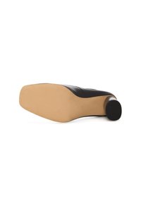 Scarpa nera con tacco alto vista dal fondo, con una suola beige e un tacco rotondo, che mette in mostra un design elegante e moderno.