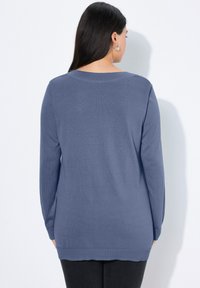 Langärmliger, lockerer Pullover in Hellblau mit geripptem Halsausschnitt und Saum. Weiche Strickstruktur, mittellanges Design und entspannter Schnitt.