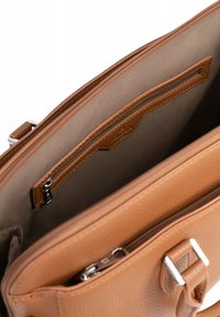 Interno della borsa in pelle marrone che mostra una texture liscia, una tasca con zip e un'altra tasca con un rivestimento marrone e una finitura in contrasto.