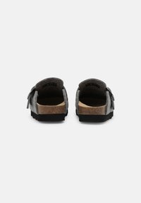 Gray felt slip-on shoes featuring a cork footbed and rubber outsole, with a rounded back and decorative bow accent.
