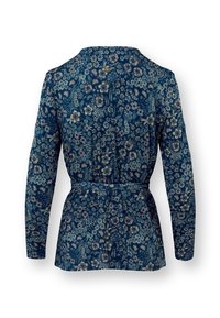 Marineblauwe blouse met bloemenpatroon, lange mouwen, een ceintuurlijn en een ronde halslijn, gekenmerkt door ingewikkelde lichtgekleurde bloemontwerpen.