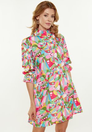 Kleurrijke, gemusterde jurk met een hoge kraag, rimpelige mouwen en een mix van roze, groen, blauw en gele vormen en bloemmotieven.