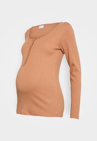 Blusa de maternidade de manga longa, na cor ferrugem, feita de um tecido suave, com decote em V e três botões na parte da frente. Design liso e ajustado.