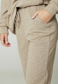 Beige sweatpants van zachte, gestructureerde stof met een elastische tailleband, trekkoord en zijzakken.