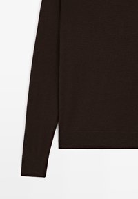 Pull marron à manches longues avec une texture douce, présentant des poignets et une ceinture côtelés, affichant un design simple et classique.