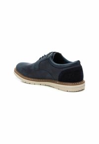 Zapatos azul marino con una combinación de texturas lisas y de ante. Presentan una punta redonda, cierre de cordones y una suela de goma de color claro con detalles de costura.