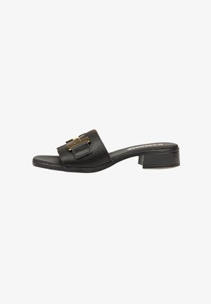 Sandalia deslizante de cuero negro con un acabado texturizado, que presenta un detalle de hebilla en tono dorado y un tacón bajo. Diseño de punta redondeada.
