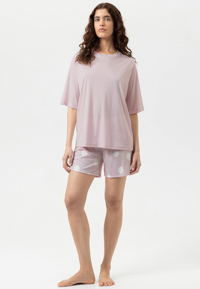 Haut à manches courtes rose clair associé à un short rose orné de gros pois blancs. Tissu doux et lisse avec une coupe décontractée.