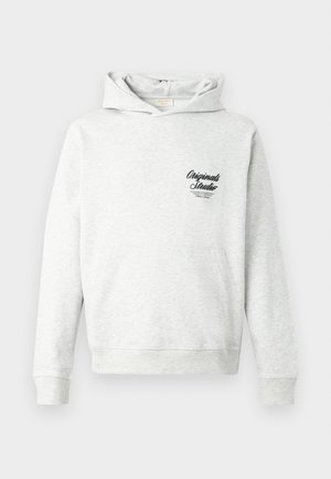 Helehall hall kapuutsiga dressipluus, millel on kängurumudel ja soonikkoes mansetid ning alumine serv. Vasakul rinnal on musta värvi "Originals Studio" graafik.