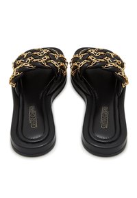 Sandales à glissière noires avec des brides en cuir tressé entrelacées de chaînes dorées, dotées de semelles rembourrées et d'orteils carrés.
