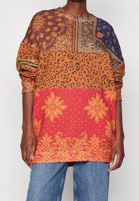 Sudadera de manga larga con vibrantes patrones mixtos: un diseño de paisley marrón, estampado de leopardo y flores rojas. Material de algodón con un corte relajado.