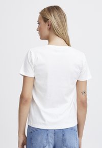 Weißes Baumwoll-T-Shirt mit Rundhalsausschnitt und kurzen Ärmeln, von hinten gezeigt. Hat eine glatte Textur und ein schlichtes Design.