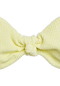 Yellow textured hair accessory shaped like a bow, featuring a central knot, made from soft, ribbed material with subtle ridges.