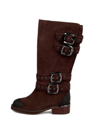 Bota de ante marrón hasta la rodilla con tres hebillas decorativas y correas con tachuelas. Cuenta con una punta redonda y un tacón mediano en bloque.