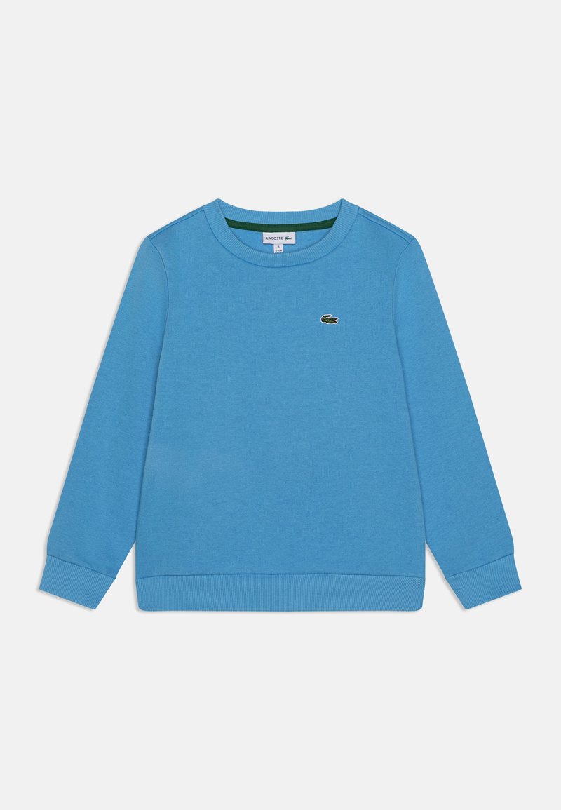 Plava pamučna dukserica dugih rukava, s rebrastim manžetama i obrubom. Ima mali zeleni Lacoste logo na prsima. Glatka tekstura.