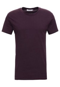T-shirt à manches courtes, col rond, de couleur violet foncé uni, coupe slim, avec une petite étiquette blanche visible à l'intérieur du col.