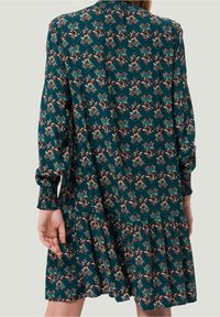 Vestido de manga larga en color teal con un patrón floral en tonos de rosa y verde, mangas fruncidas y un dobladillo de volantes en capas.