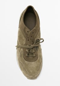 Olive green suede sneaker with tonal laces, perforated toe box, and a smooth leather lining. Features a rounded toe and a subtle, textured design.