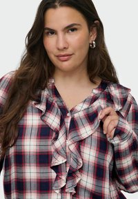 Camicia a quadri rossi e blu con frontale arricciato, design con bottoni, tessuto morbido, maniche lunghe e colletto classico.