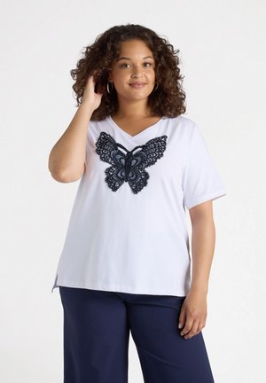 White short-sleeve T-shirt featuring a large black lace butterfly design on the front, with a V-neckline and a relaxed fit.