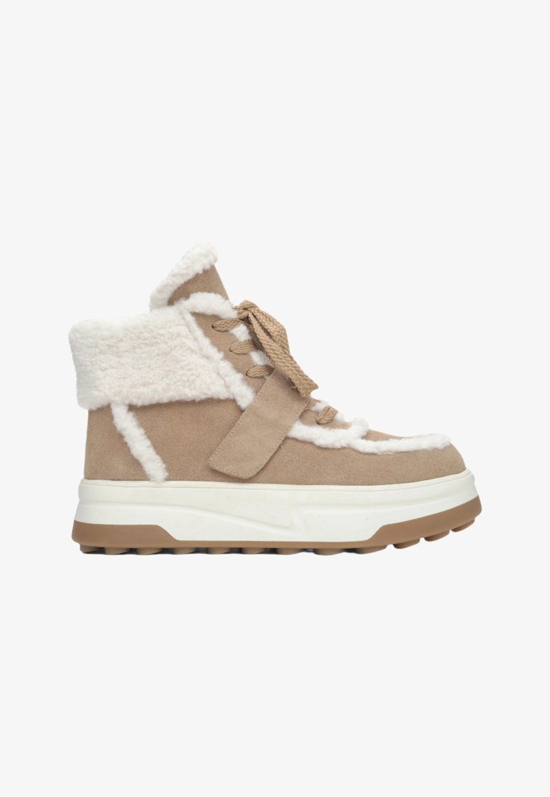 Beige enkellaars met nepbontvoering, bovenwerk van suede, veters en bandjesluiting, dikke witte tussenzool en rubberen buitenzool met grip.