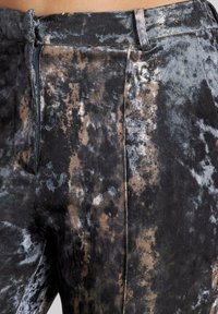 Samt-Hosen mit einem dunkelgrauen und braunen Batikmuster, einem glatten Material und einem Frontreißverschluss.