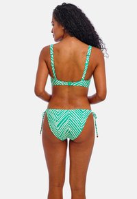 Groen en wit gestreepte bikini, met een driehoekige top met verstelbare banden en een broekje met strikzijden. Gladde textuur en gedurfd patroon.