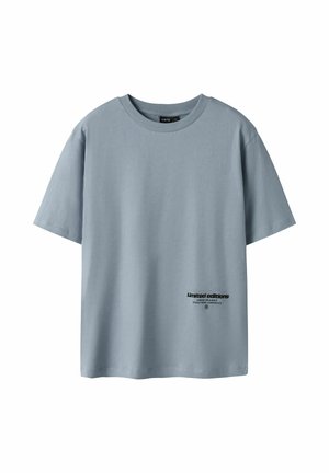 T-shirt bleu clair à manches courtes et col rond, avec un petit texte noir « Éditions limitées » près de l'ourlet inférieur à l'avant.