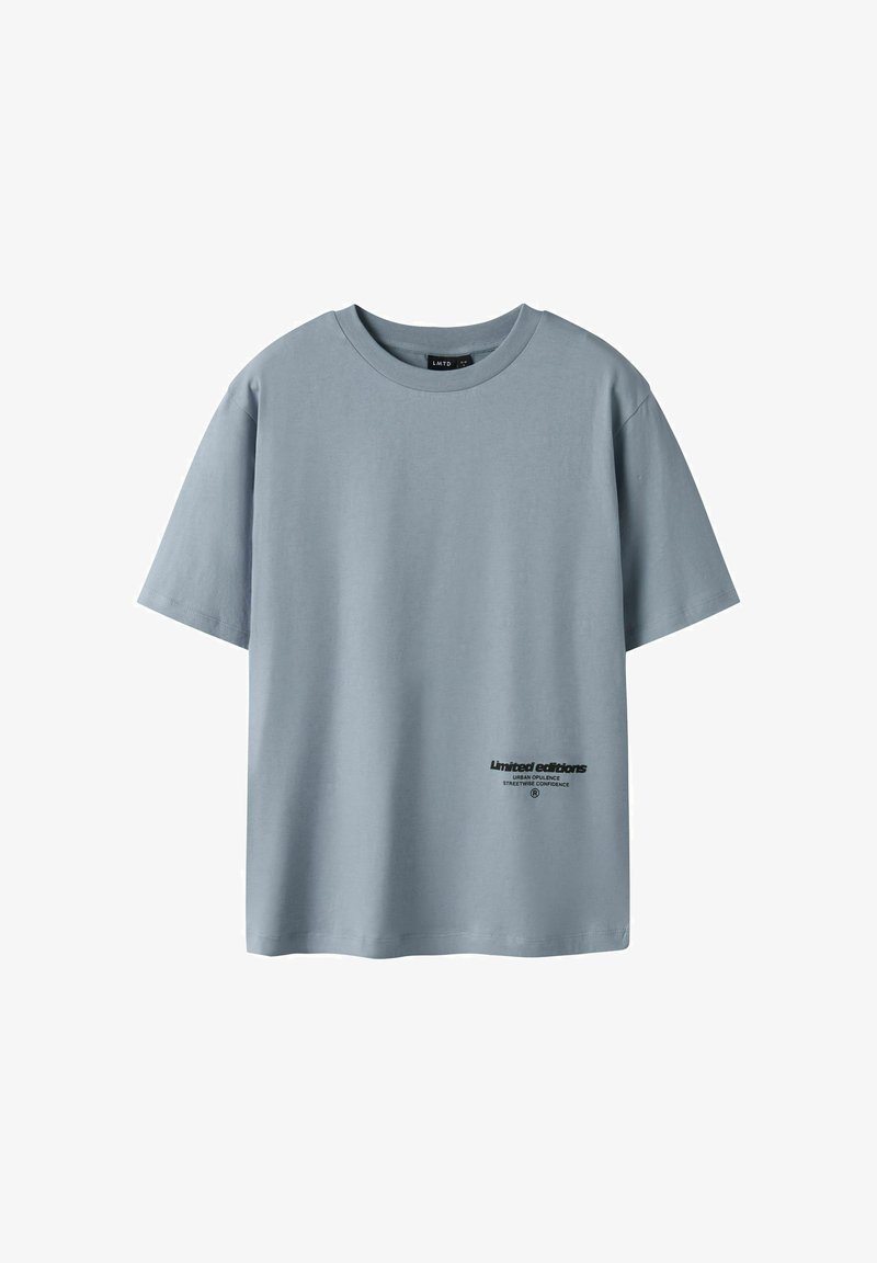 T-shirt bleu clair à manches courtes et col rond, avec un petit texte noir « Éditions limitées » près de l'ourlet inférieur à l'avant.