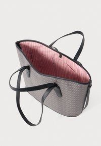 Saco tote cinza com padrão e alças de couro preto. O interior apresenta um forro rosa com riscas verticais e um pequeno bolso.