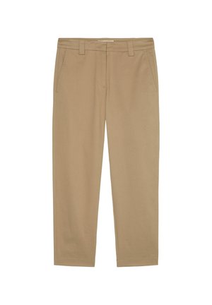 Close-up van een persoon die beige hoge taillebroeken draagt met ceintuurlussen en een achterzak met split, staand met de arm langs het lichaam.