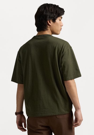 Tricou din bumbac de culoare verde măsliniu, cu mâneci scurte, croială lejeră și decolteu rotund, văzut din spate. Design simplu și uniform.