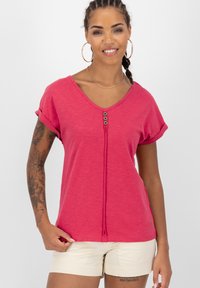 Roze T-shirt met korte mouwen en een v-hals, versierd met drie decoratieve knopen aan de voorkant en opgerolde mouwen. Gemaakt van lichte stof met een zachte textuur.