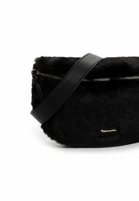 Borsa in ecopelliccia nera con una elegante tracolla in pelle nera, chiusura con zip e un accento del logo dorato. Design curvo e compatto. Texture morbida.