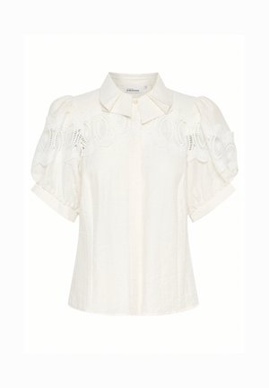 White linen blouse with a collared neckline, short puff sleeves, and intricate lace detail along the shoulders. Textured, lightweight fabric.
