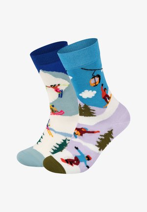 Knee-high socks featuring two designs: one with skiers and mountains in muted colors, the other with snowboarders against a blue background.