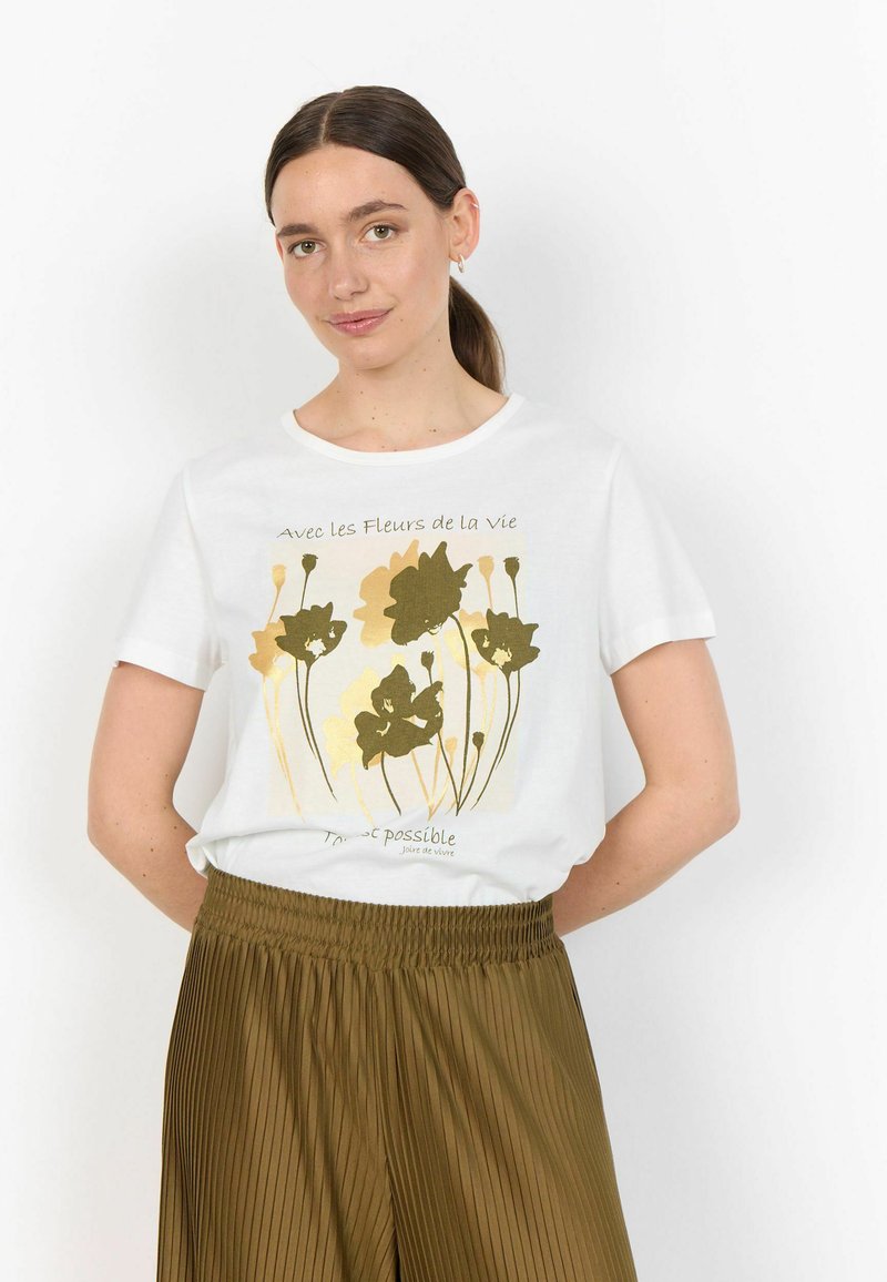 T-shirt bianca in cotone con una grafica floreale in tonalità oro e verde, maniche corte, scollo rotondo, abbinata a pantaloni plissettati color olive.